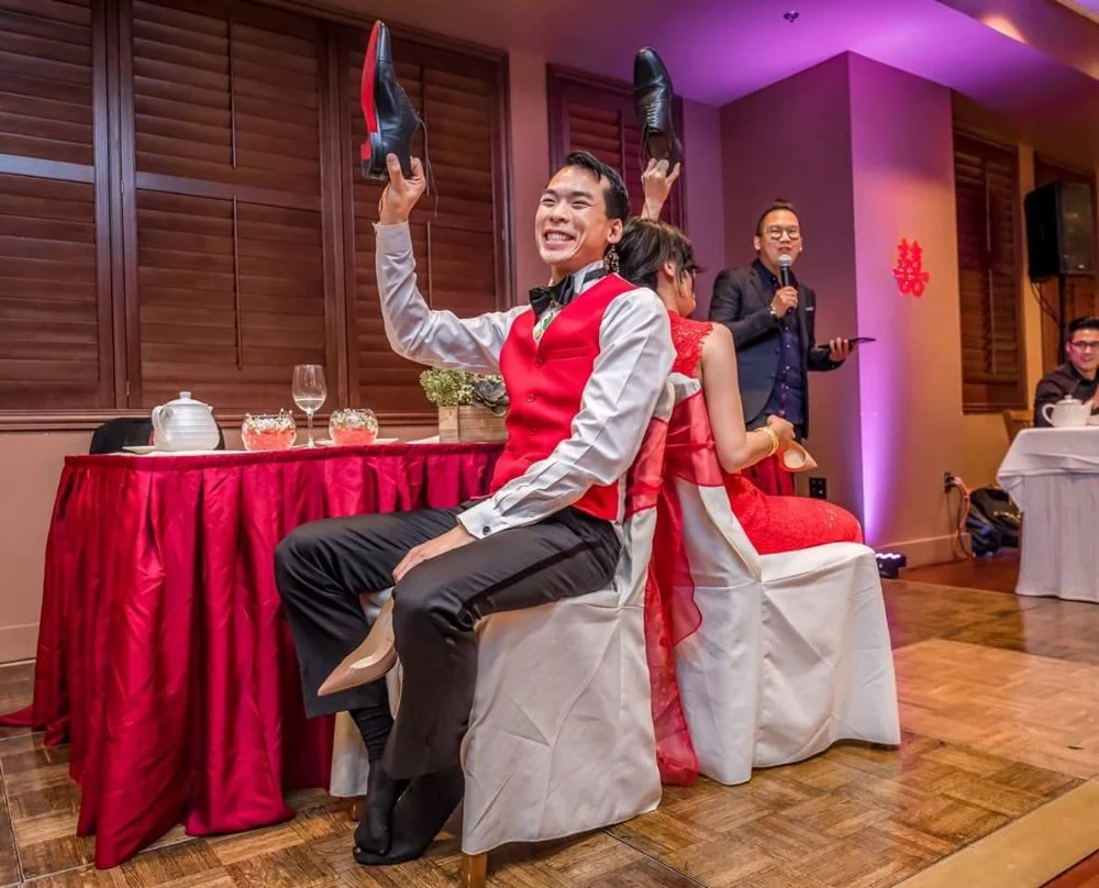 Foksifu hosting Chinese wedding banquet games at a Bay Area reception with a double-happiness backdrop